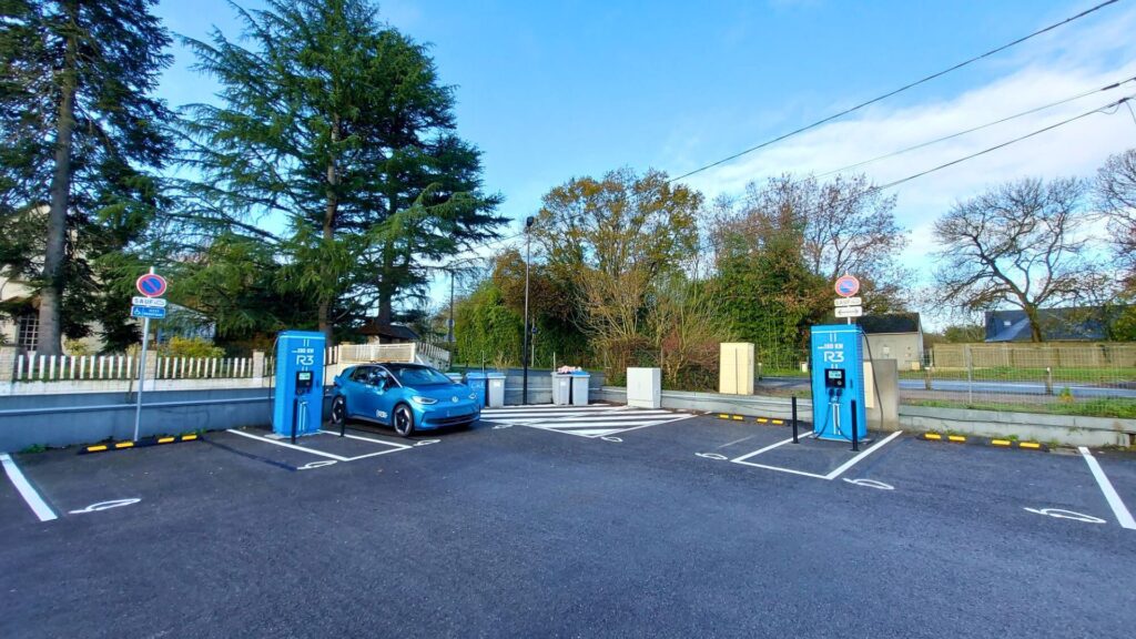 Station de recharge pour véhicules électriques sur un parking public avec bornes rapides et voiture électrique en charge, infrastructure de mobilité durable favorisant la transition énergétique et les transports écologiques.