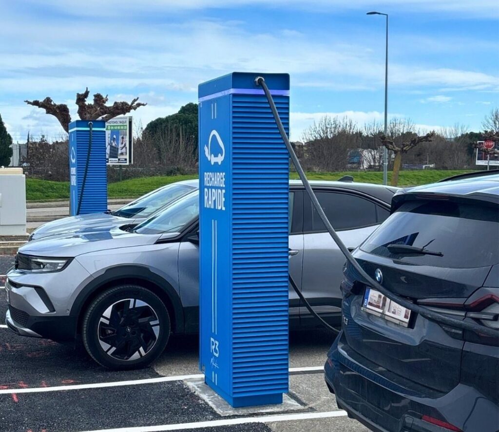 Borne de recharge rapide pour voiture électrique sur parking, avec véhicules branchés en station de recharge moderne